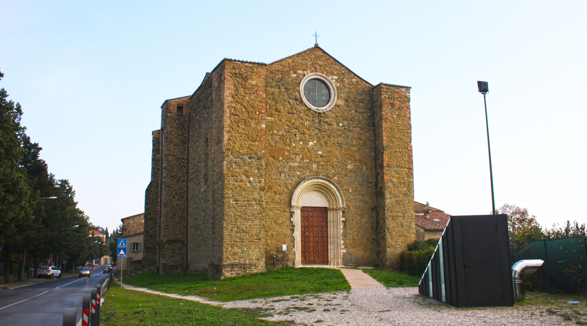 Façade of the ancient Templar church of San Bevignate in Perugia, stone building with rose window and Romanesque portal.