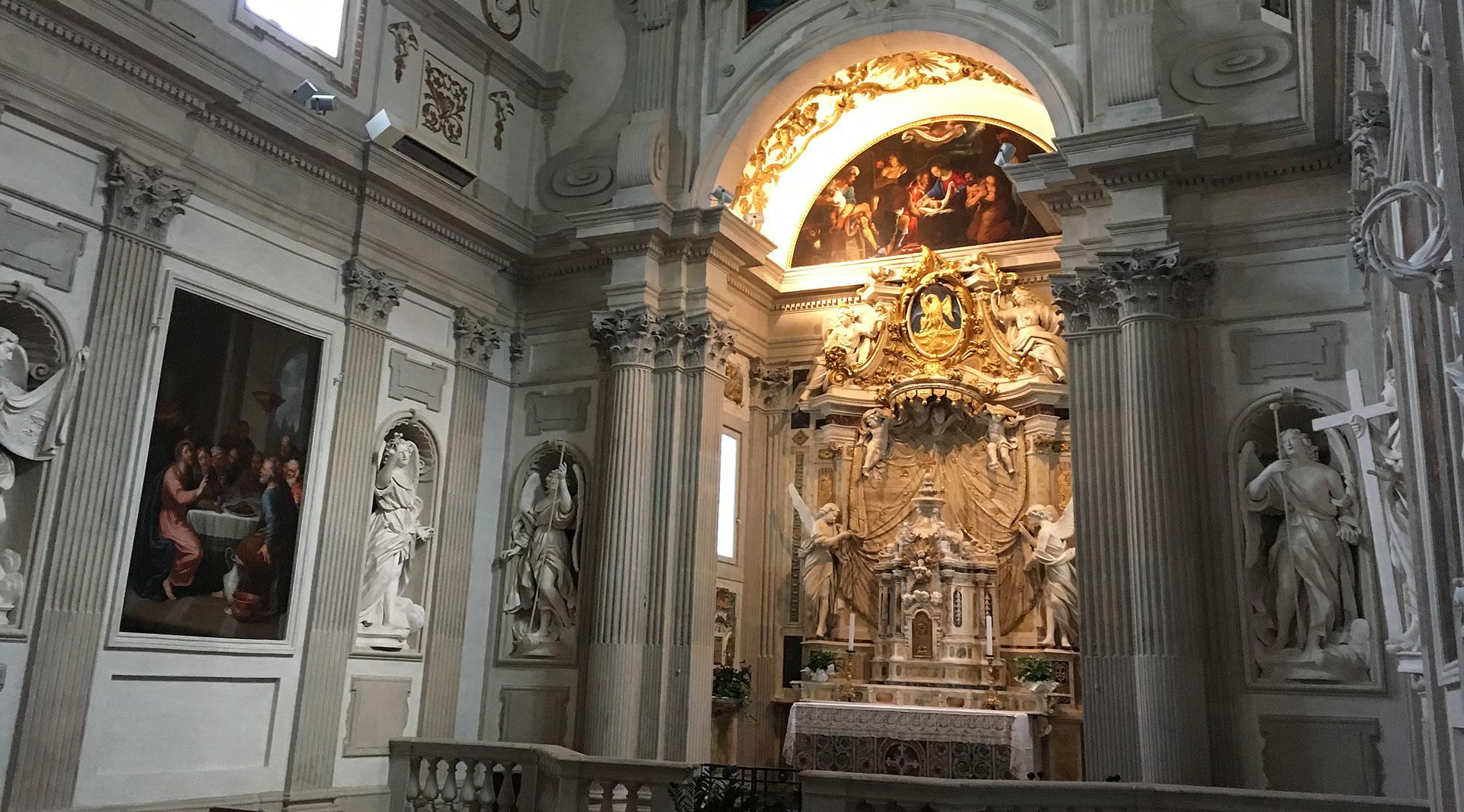 Baroque chapel in Spoleto Cathedral, featuring a decorated altar, sculptures, columns, paintings, and an illuminated fresco above.