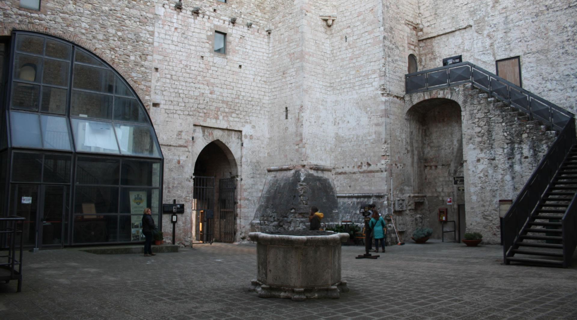Il cortile interno della Rocca di Narni, con il pozzo centrale, le mura medievali e le scale di accesso in pietra