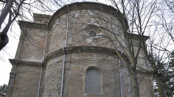  Rear facade of the Sanctuary of Madonna dei Miracoli, featuring a large central window and a skylight positioned at the top, allowing natural light to enter the building. 