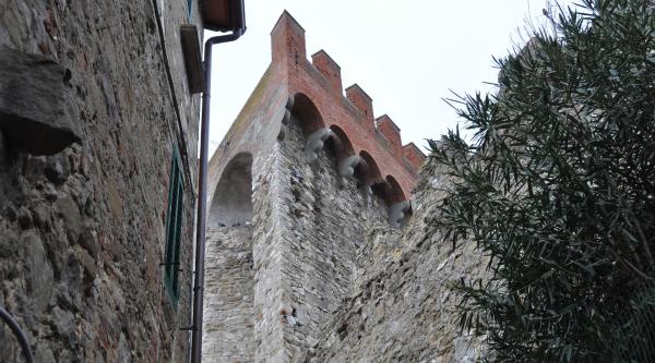  Detail der Tower der Rocca di Passignano, die ihre charakteristische dreieckige Form in Mauerwerk hervorhebt, die sich in der Landschaft abhebt. 