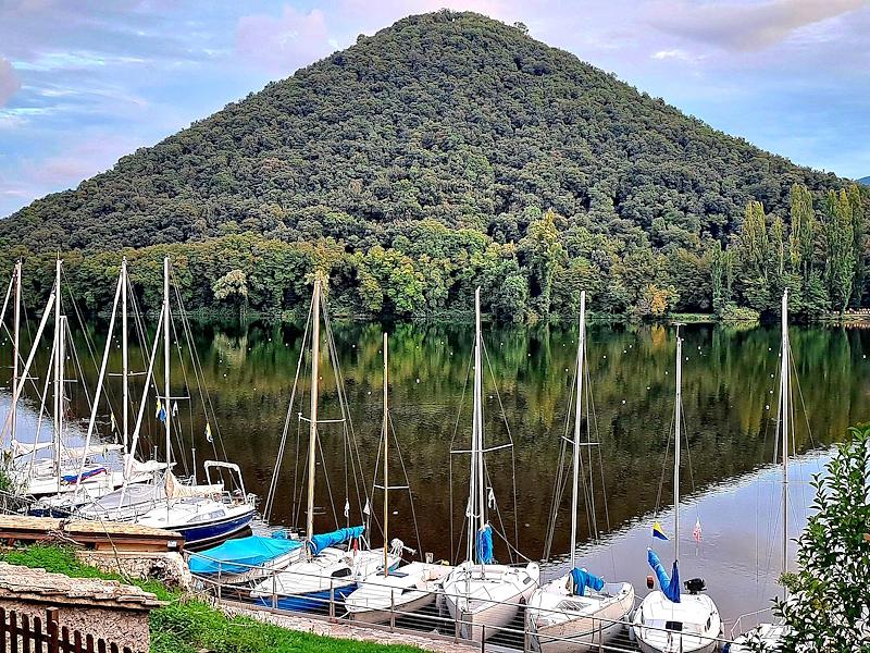 Segelboote auf dem Lago di Piediluco mit dem pyramidenförmigen Profil des Monte Caperno im Wasser gespiegelt.