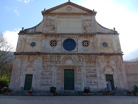 Fassade der Kirche San Pietro mit ihren Flachreliefs an einem sonnigen Frühlingstag, erbaut am Fuße des Monteluco