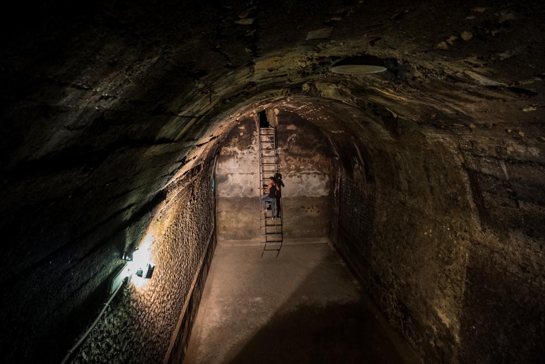 Eine Person, die eine Treppe in einem der Räume der römischen Zisterne in Amelia hinaufsteigt