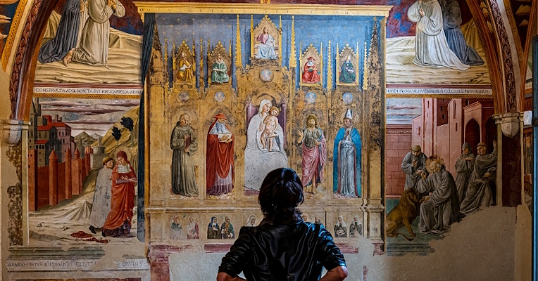 girl admiring the cycle of frescoes with the Stories of St Francis by Benozzo Gozzoli in the Museo di San Francesco in Montefalco.