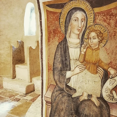 Fresco inside the Church of Santa Pudenziana depicting the Madonna and Child. The Madonna is shown seated, with the Child Jesus on her lap holding a scroll of parchment.