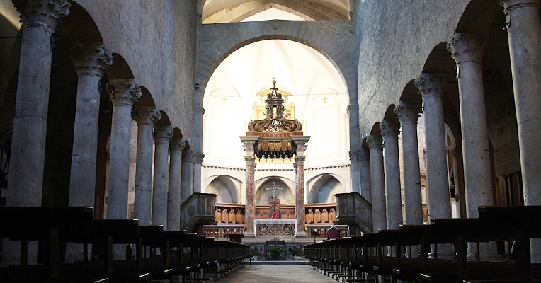 Zentrales Kirchenschiff der Kathedrale des Heiligen Juvenal mit Säulen und Gewölbedecke, dekorierter Altar im Hintergrund und gedämpftes Licht.