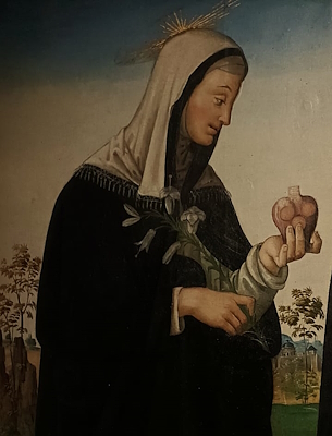 Gemälde der Seligen Margareta in schwarzem Gewand mit goldenem Heiligenschein, hält ein Herz und eine Lilie, vor landschaftlichem Hintergrund.