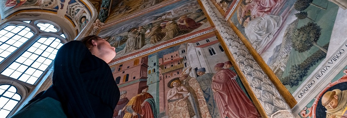 girl admiring the cycle of frescoes with the Stories of St Francis by Benozzo Gozzoli in the Museo di San Francesco in Montefalco.