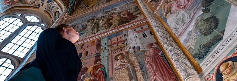 Immagine: girl admiring the cycle of frescoes with the Stories of St Francis by Benozzo Gozzoli in the Museo di San Francesco in Montefalco. 