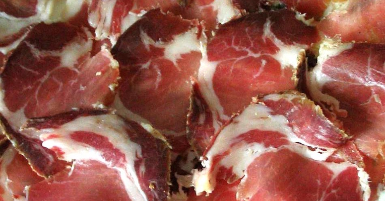 Fette di capocollo con il caratteristico colore rosso della carne e le venature bianche di grasso