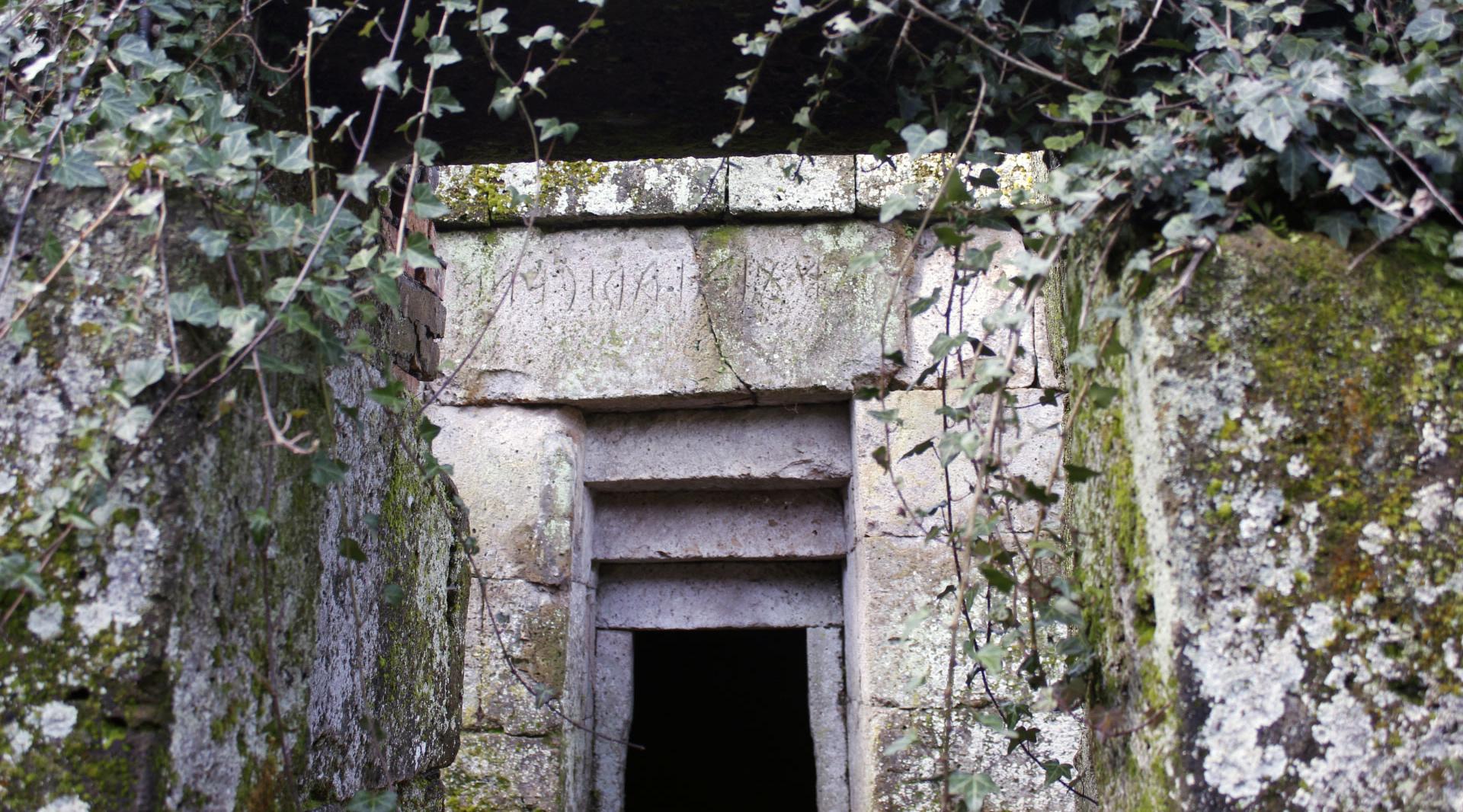 Entrée d’une tombe étrusque en pierre avec le nom gravé sur le linteau au-dessus de la porte.